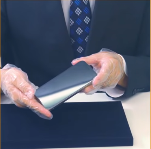 手袋を着けた手でスマートフォンを扱う、ルブリコーティングの施工動画の一場面